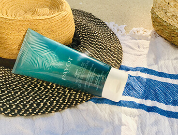 Gel douche Payot avec une chapeau et une serviette de plage