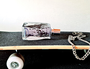 Parfum D by Diesel sur un skateboard.